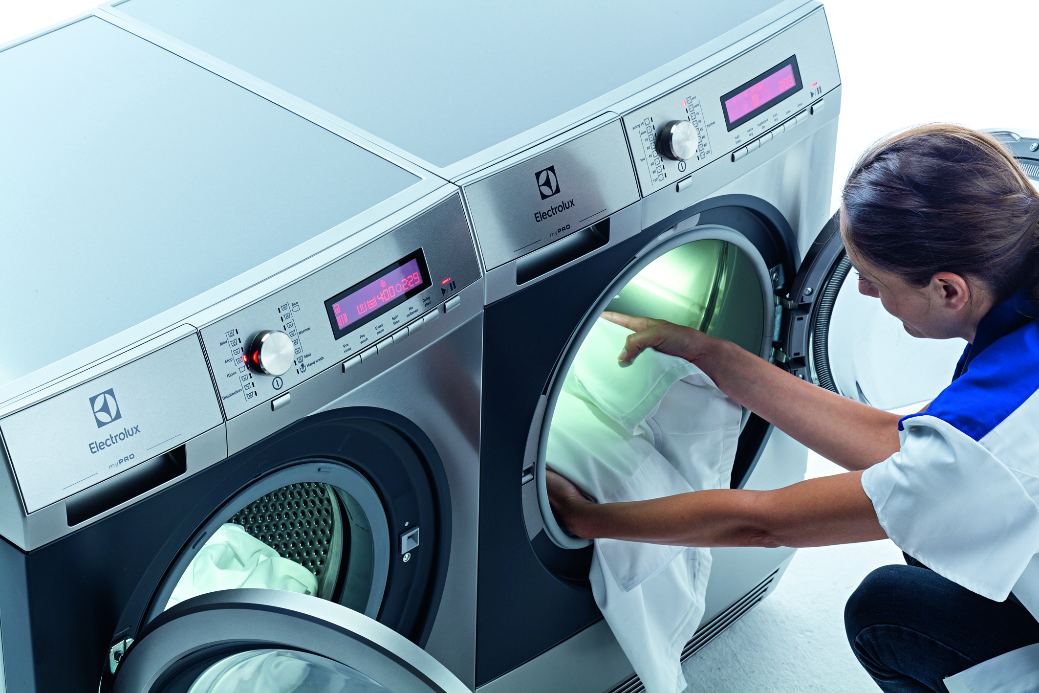 Eine Mitarbeiterin befüllt eine Profi-Waschmaschine