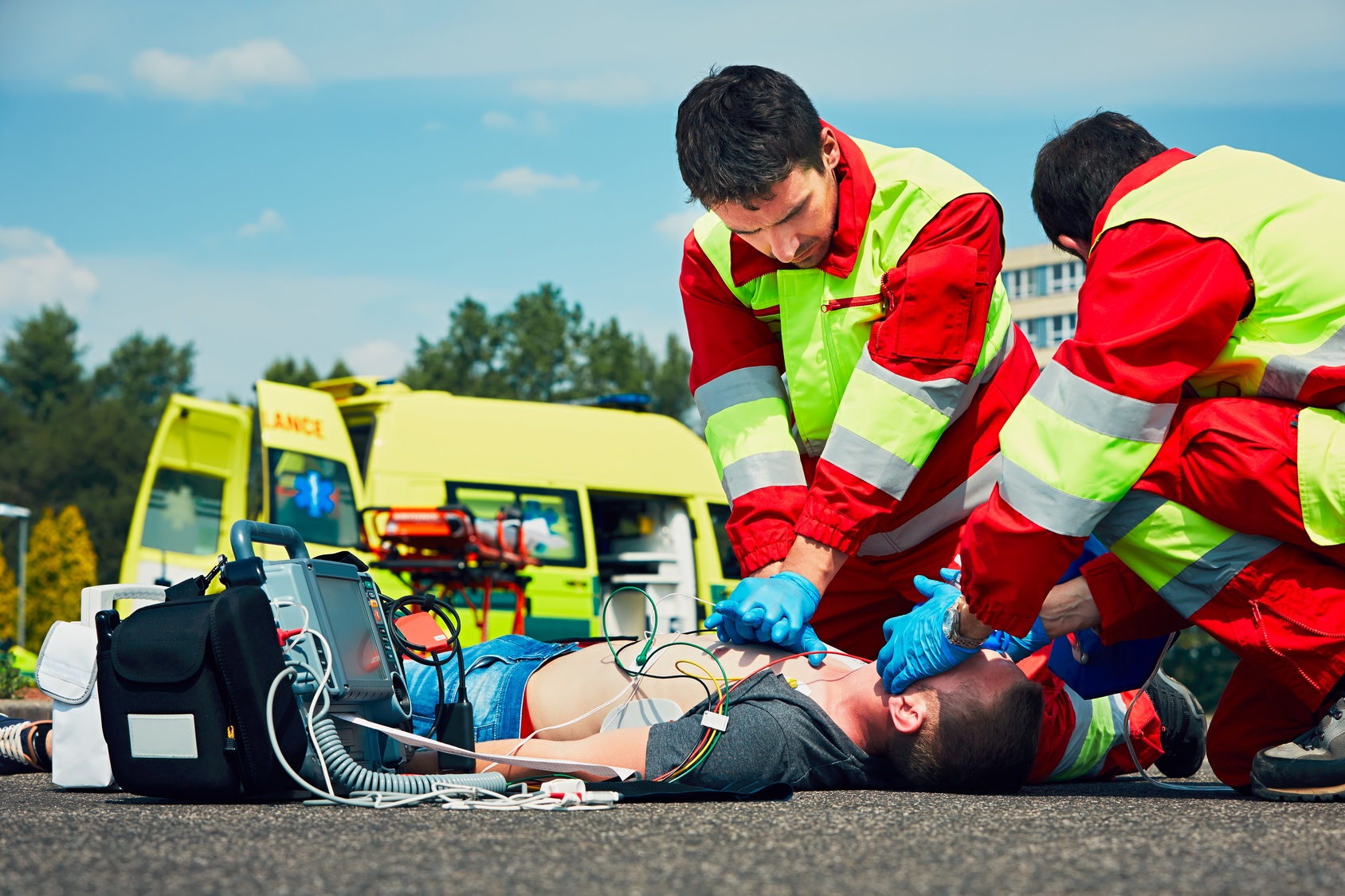 Zwei Rettungssanitäter reanimieren eine am Boden liegende Person